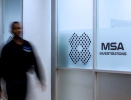 office employee walking down hallway next to MSA investigations glass decal