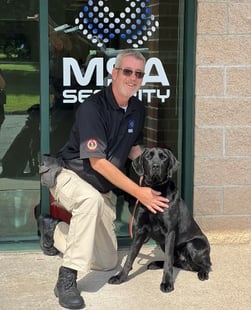 Handler Scott & Canine Seth Pose for photo in front of MSA Logo